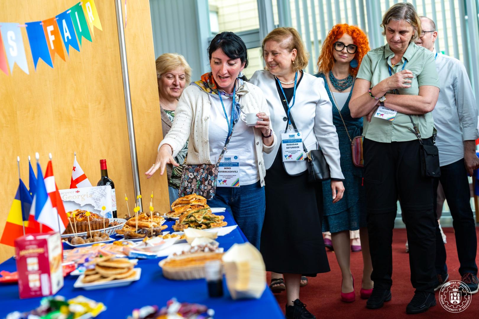 Participants looking at a table with traditional dishes from Georgia during an international refreshment session.