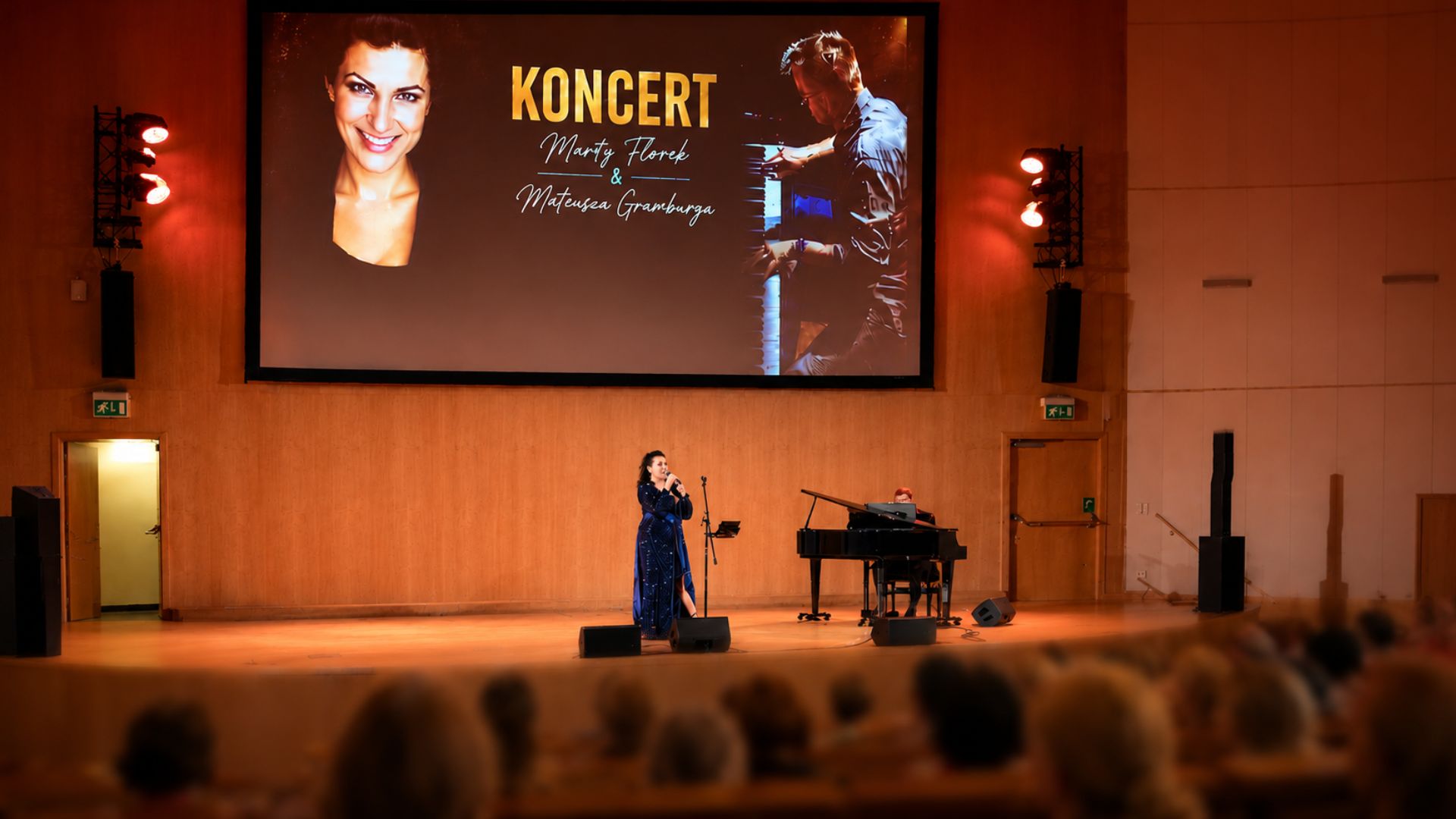 Koncert Marty Florek i Mateusza Gramburga na scenie z fortepianem; publiczność ogląda występ z widowni.