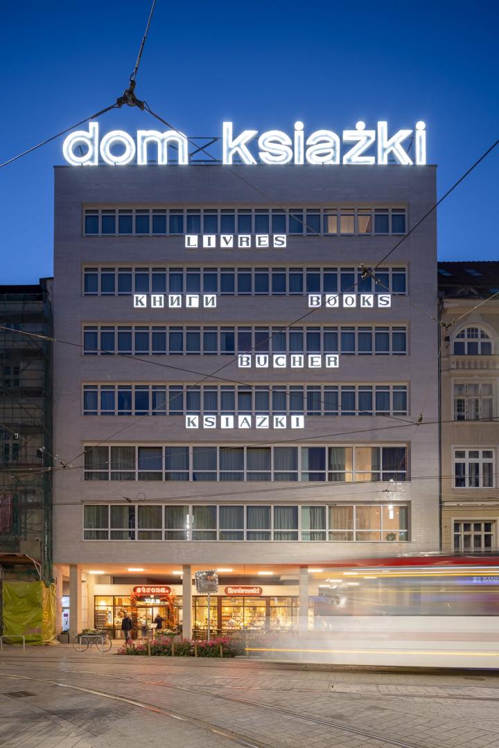 Podświetlona iluminacja fasady budynku „Dom Książki” w Poznaniu o zmierzchu.