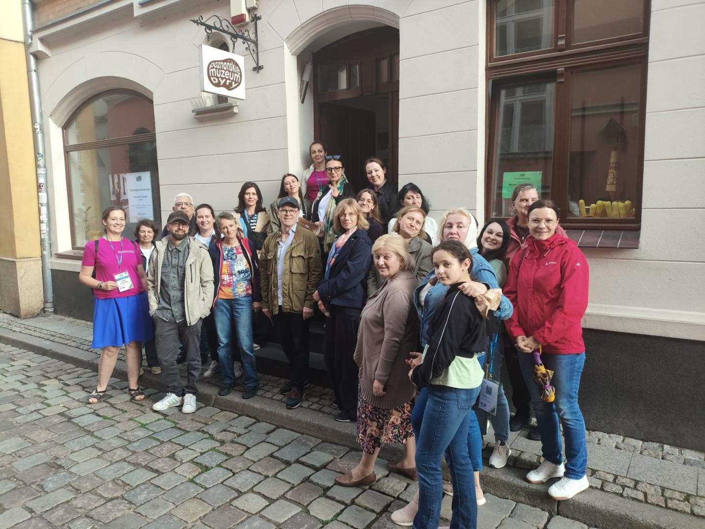 A group of participants posing for a group photo in front of the entrance to the Poznań Potato Museum.