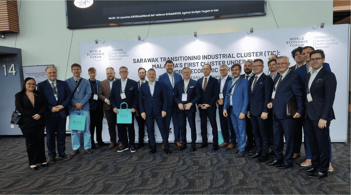 Pamiątkowe zdjęcie grupowe wszystkich uczestników wielkopolskiej misji oraz malezyjskich gospodarzy na tle oficjalnej ścianki Światowego Forum Ekonomicznego (World Economic Forum) w Kuching.