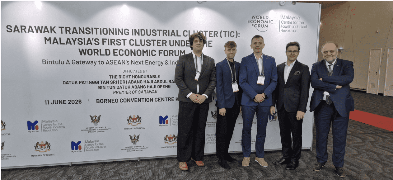 Naukowcy i studenci Politechniki Poznańskiej pozujący razem na tle ścianki prasowej wydarzenia „Sarawak Transitioning Industrial Cluster (TIC)” w Borneo Convention Centre.