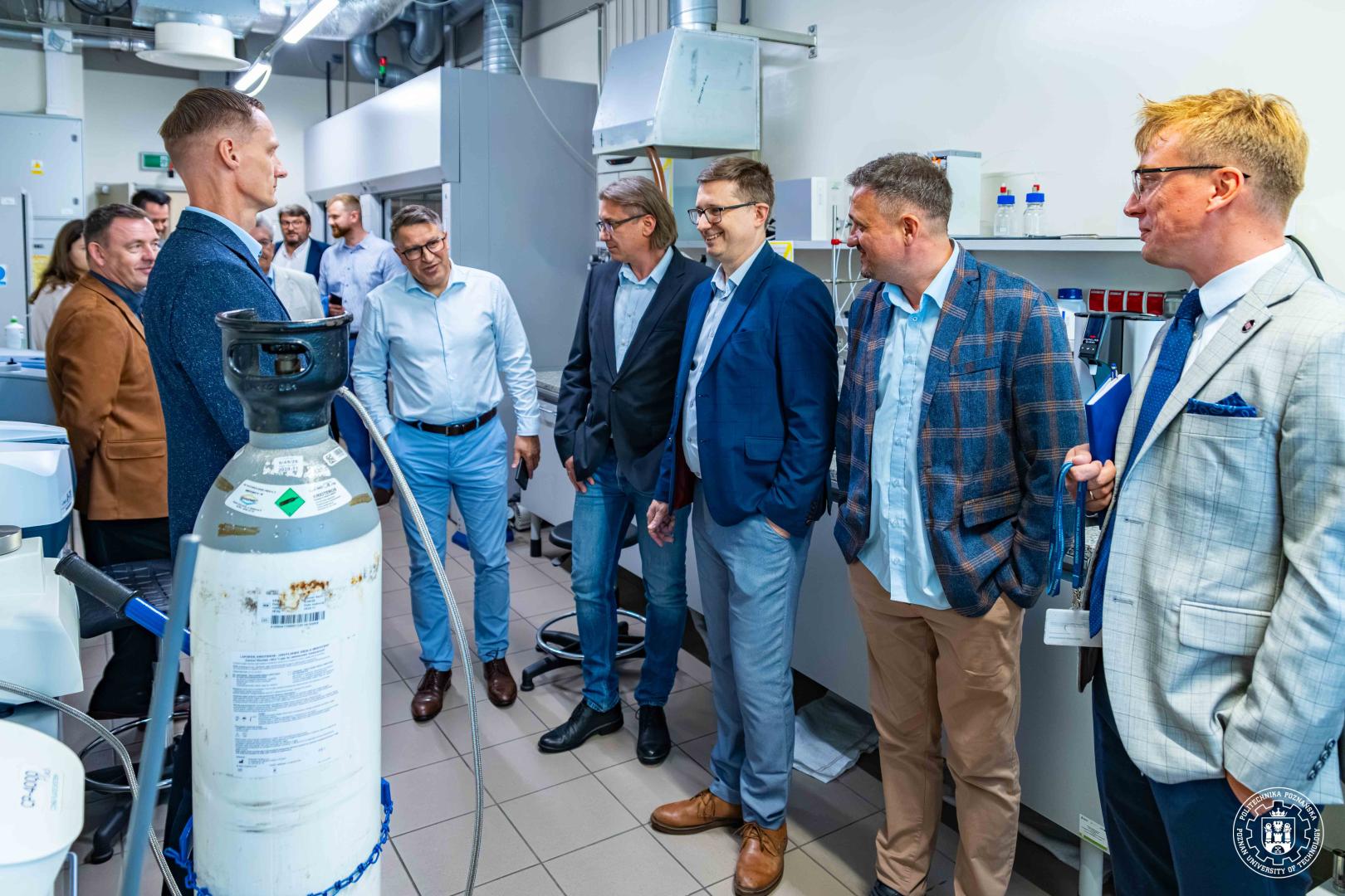 Rektor Teofil Jesionowski i przedstawiciele ORLEN S.A. podczas wizyty w laboratorium chemicznym Politechniki Poznańskiej.