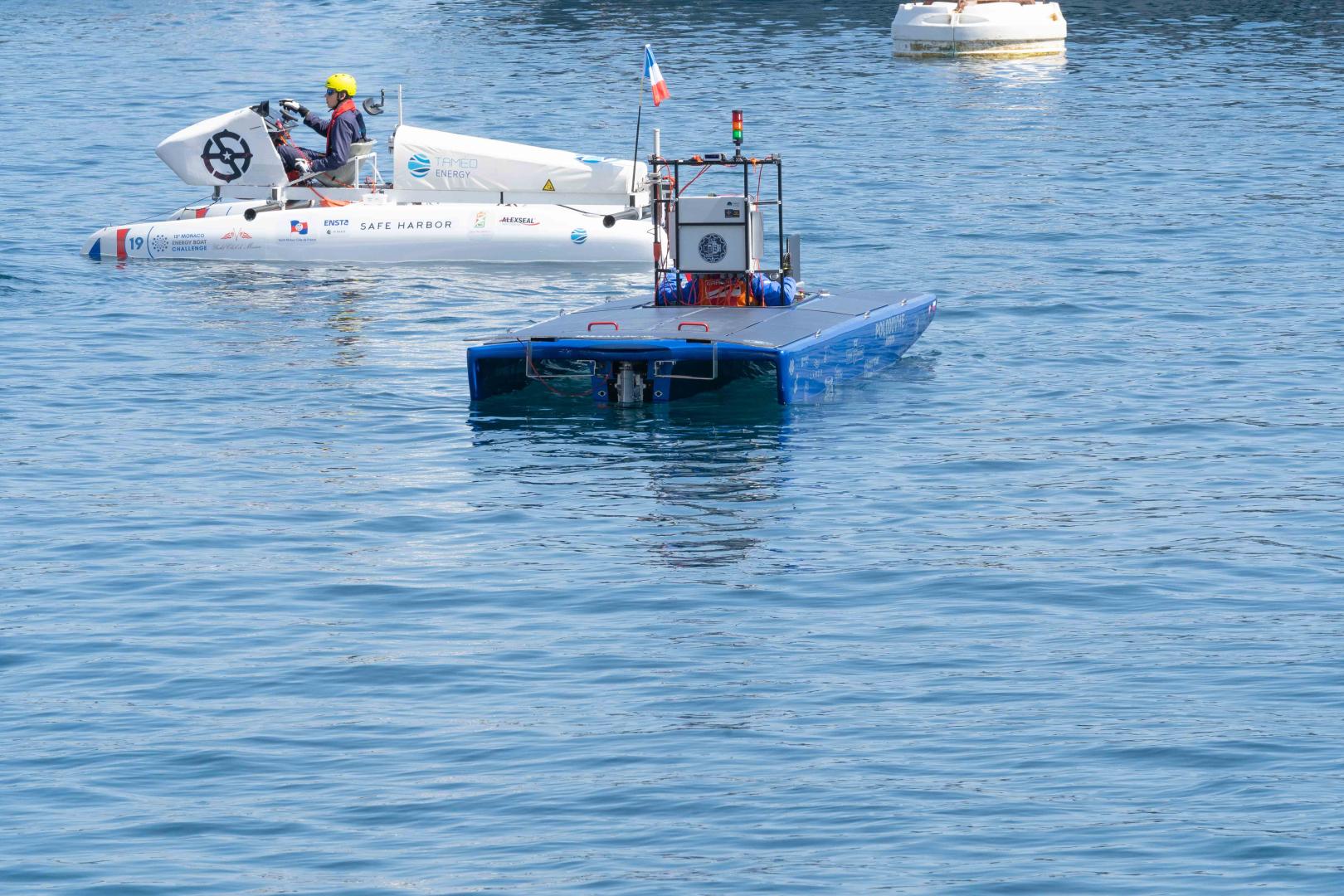 Autonomiczna łódź solarna zespołu PUT Powertrain płynie po akwenie podczas zawodów Monaco Energy Boat Challenge. W tle widoczna inna jednostka.
