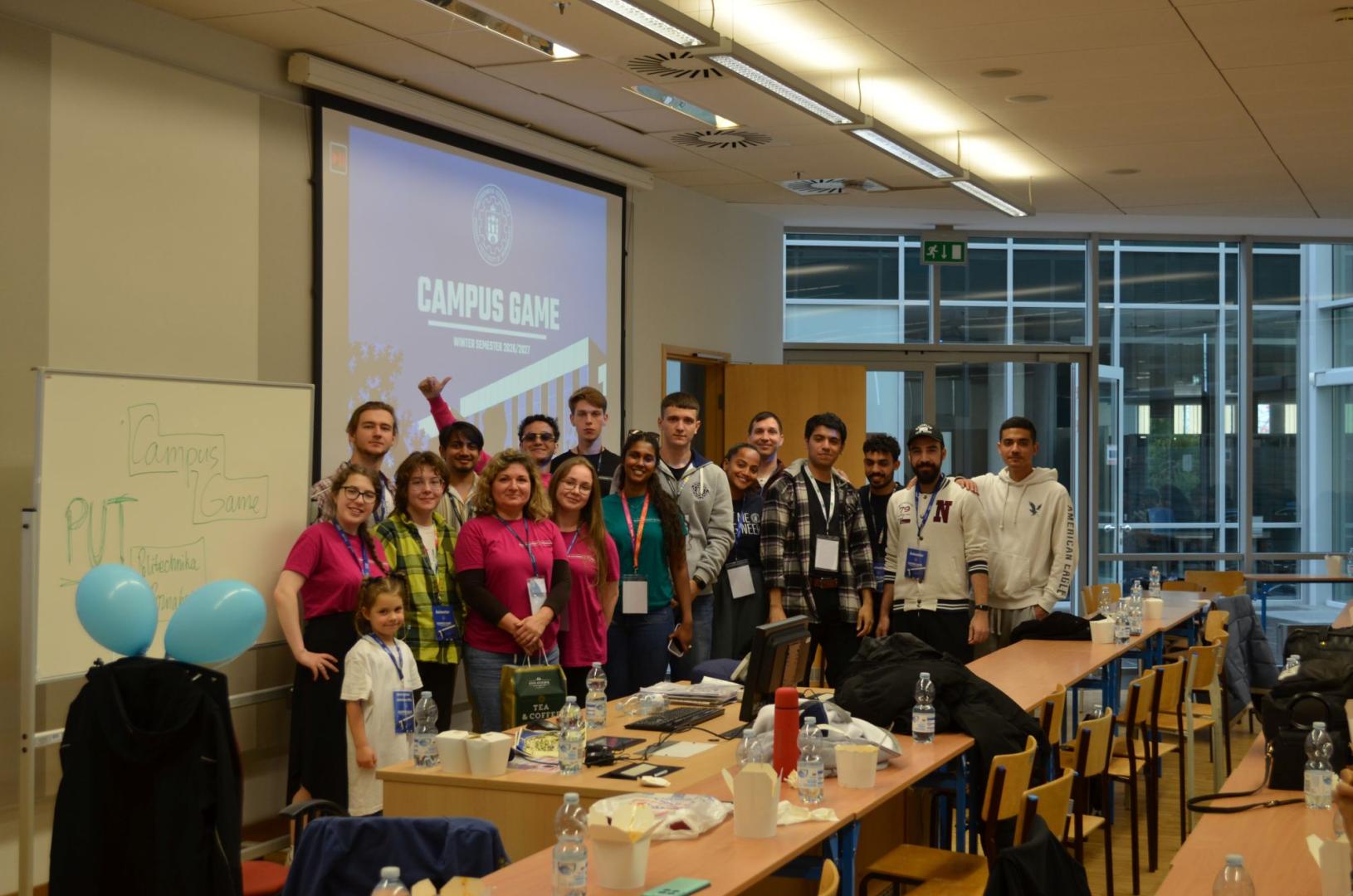 Participants and organizers pose for a photo in a lecture hall in front of a screen reading "CAMPUS GAME Winter Semester 2026/2027".