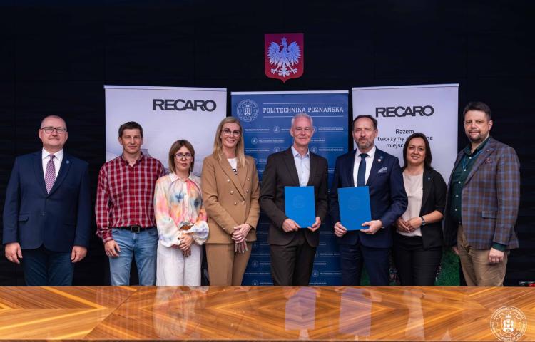 Przedstawiciele Politechniki Poznańskiej i RECARO pozują do zdjęcia z podpisanymi umowami o współpracy